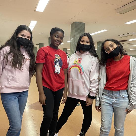 four students standing together in school