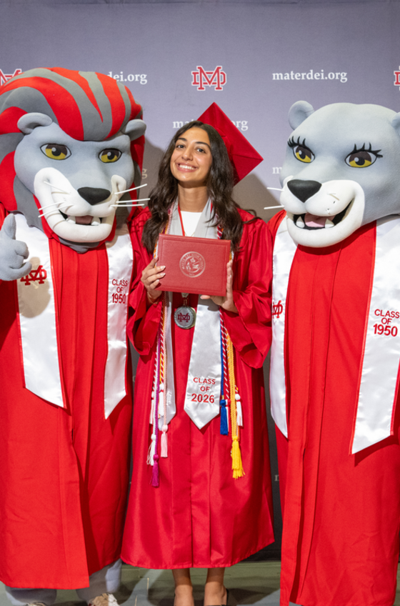 Graduate in red cap and gown holds diploma, flanked by mascot characters.