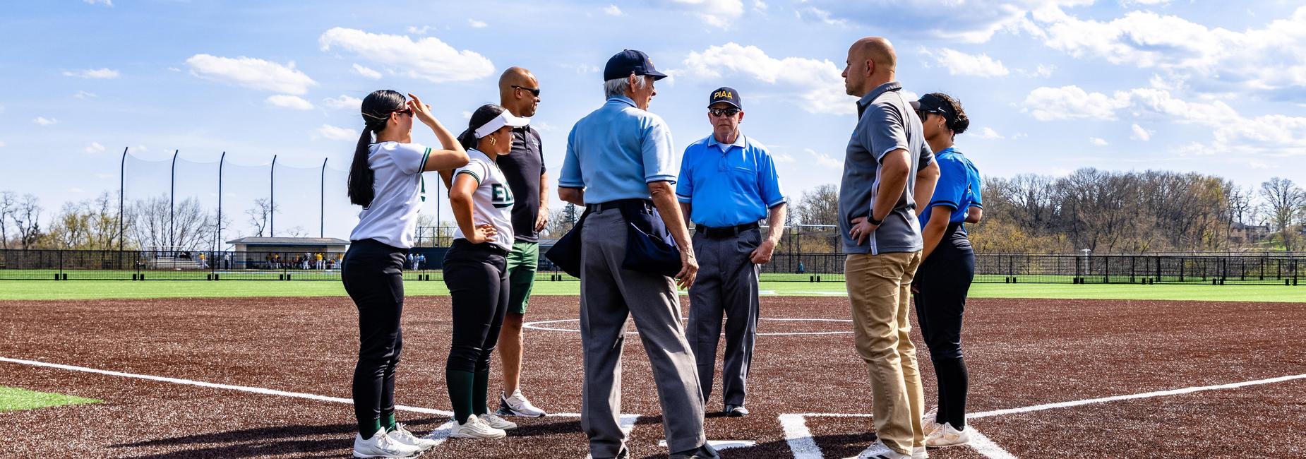 Softball players meet before a game
