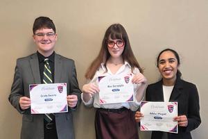Three students hold the certificates they won