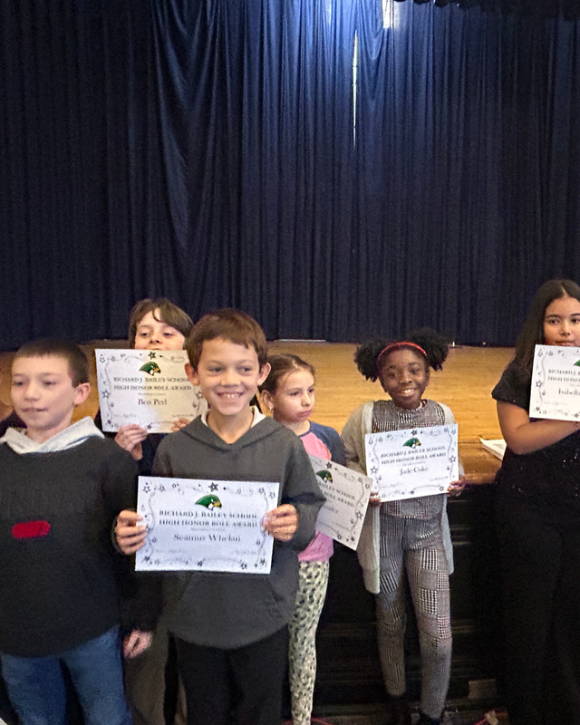 Students hold Certificates at assembly