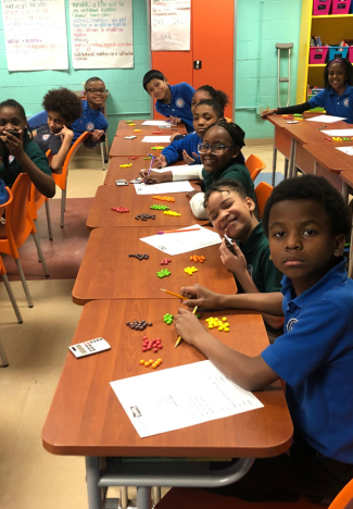 kids at desks smiling