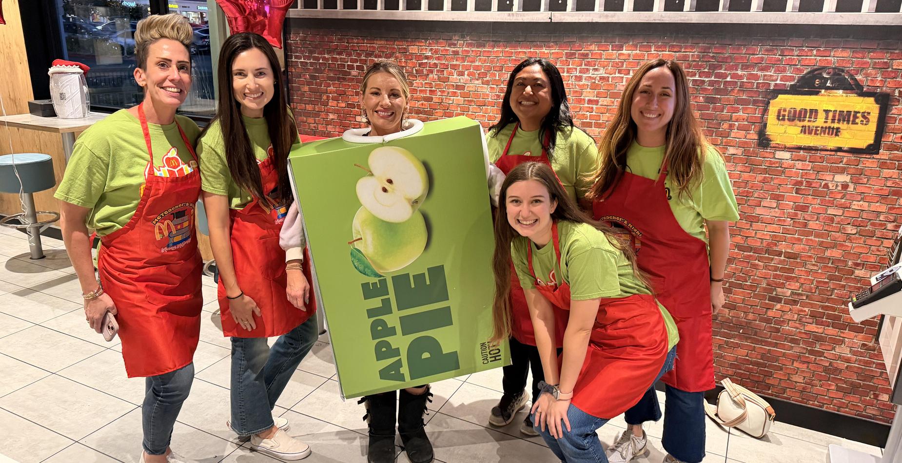 Teachers at McDonalds in aprons and a pie costume