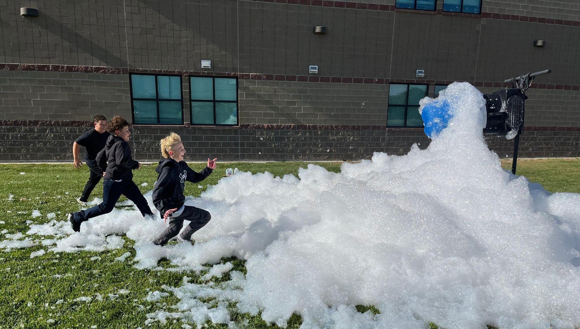3 students running through foam