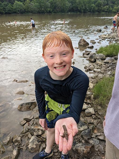 James River Day School student discovering a crawdad in the James River.