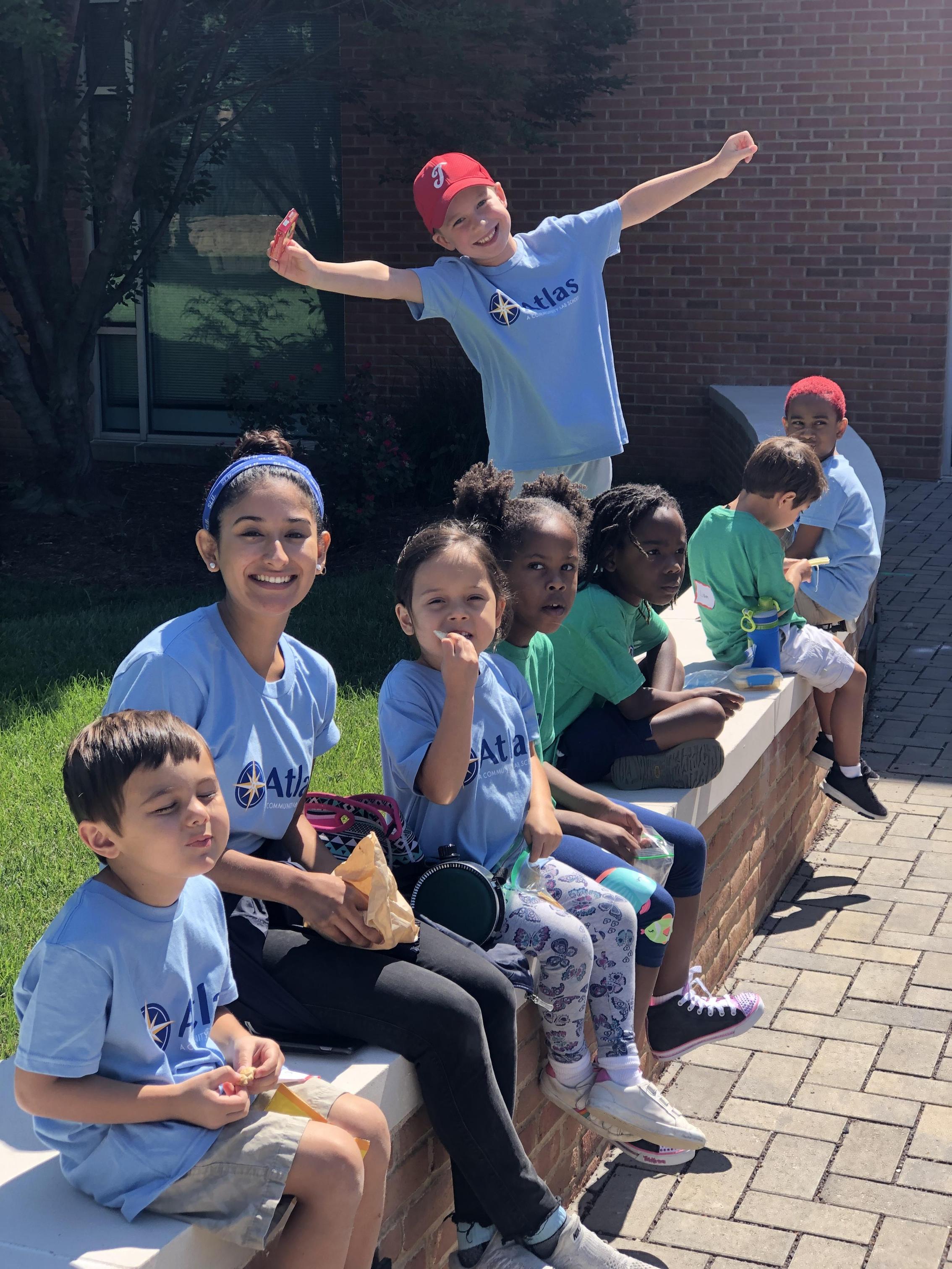 Students sitting on the wall with Ms. Garcia