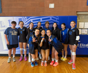 Varsity Volleyball poses with Coach Kitchen to celebrate her 500th win.