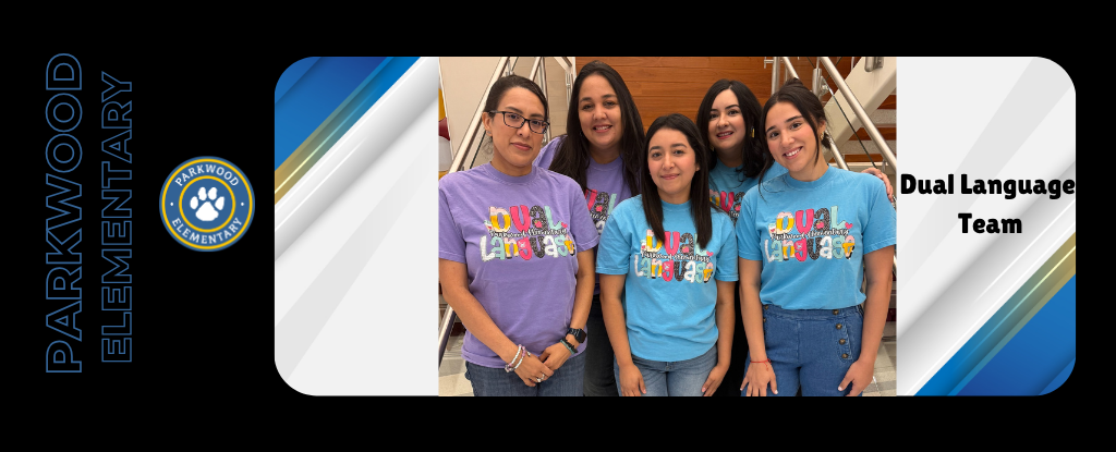 Group of five women smiling, wearing colorful shirts, in a school setting.