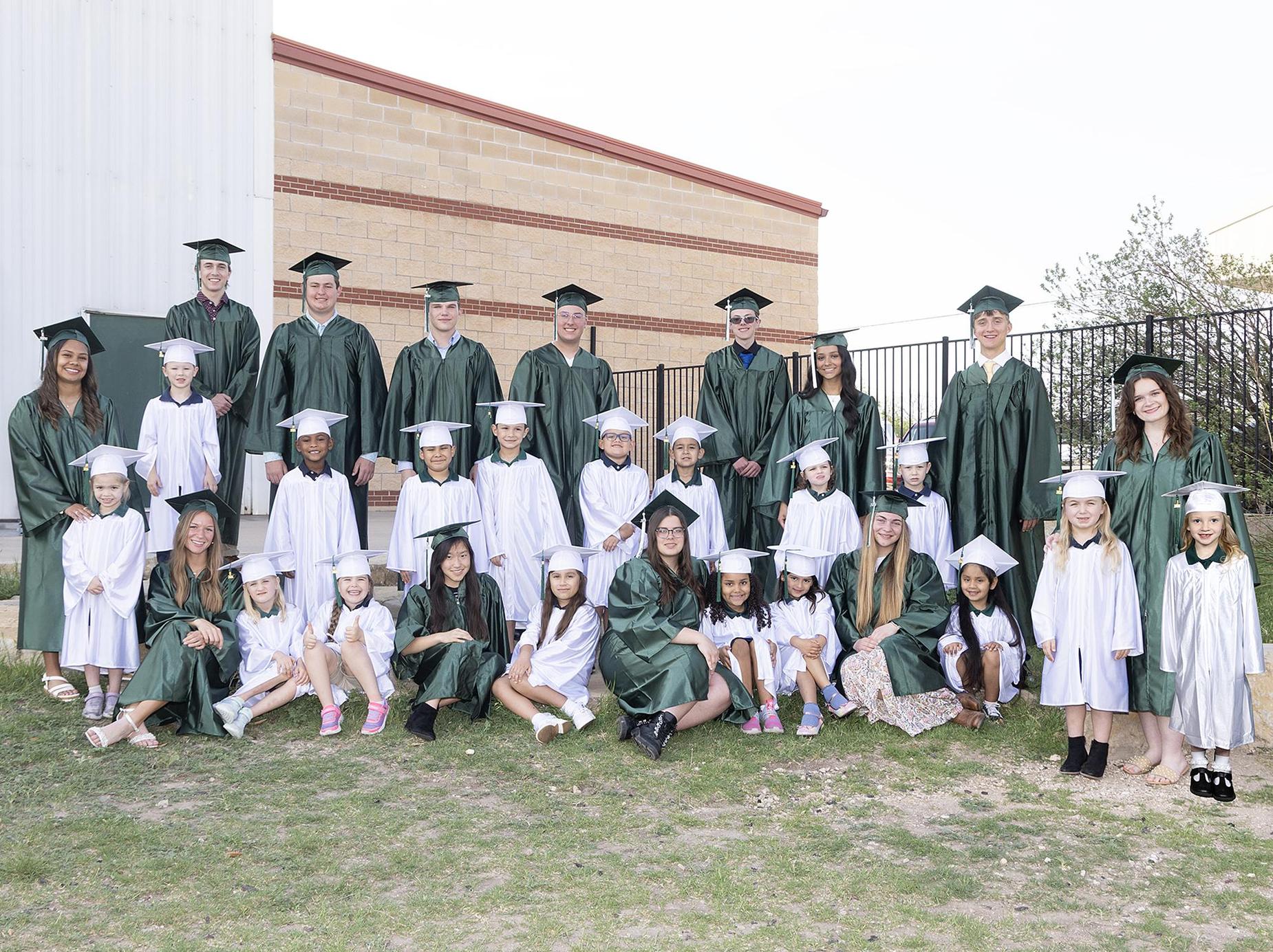 Seniors and kindergarteners in caps and gowns