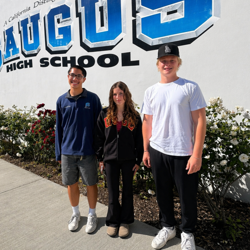 Three students pose in front of the Saugus High School Mural