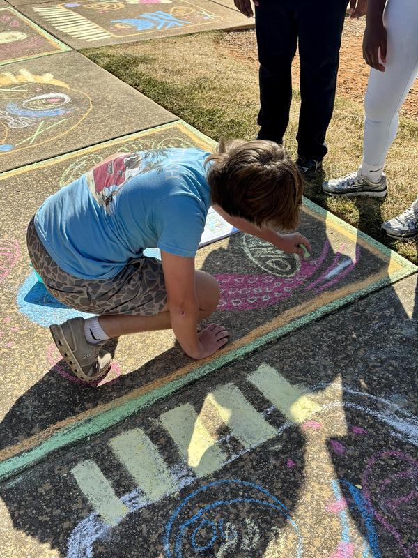 Group of students working on sidewalk art of the cell