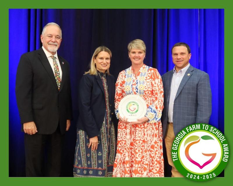 Four leaders—Richard Woods, Holly Thaw, Tyler Harper, and Nicole Blalock—pose together after Banks County Schools is recognized with the Georgia Farm to School Award.
