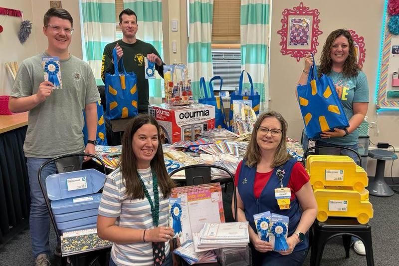 Wal-Mart team lead, Dawn Kistler (front-right), presents donated items to Penn Middle School teachers Samantha Foster, Miles Edmiston, Bob Divens, and Maria Frontz