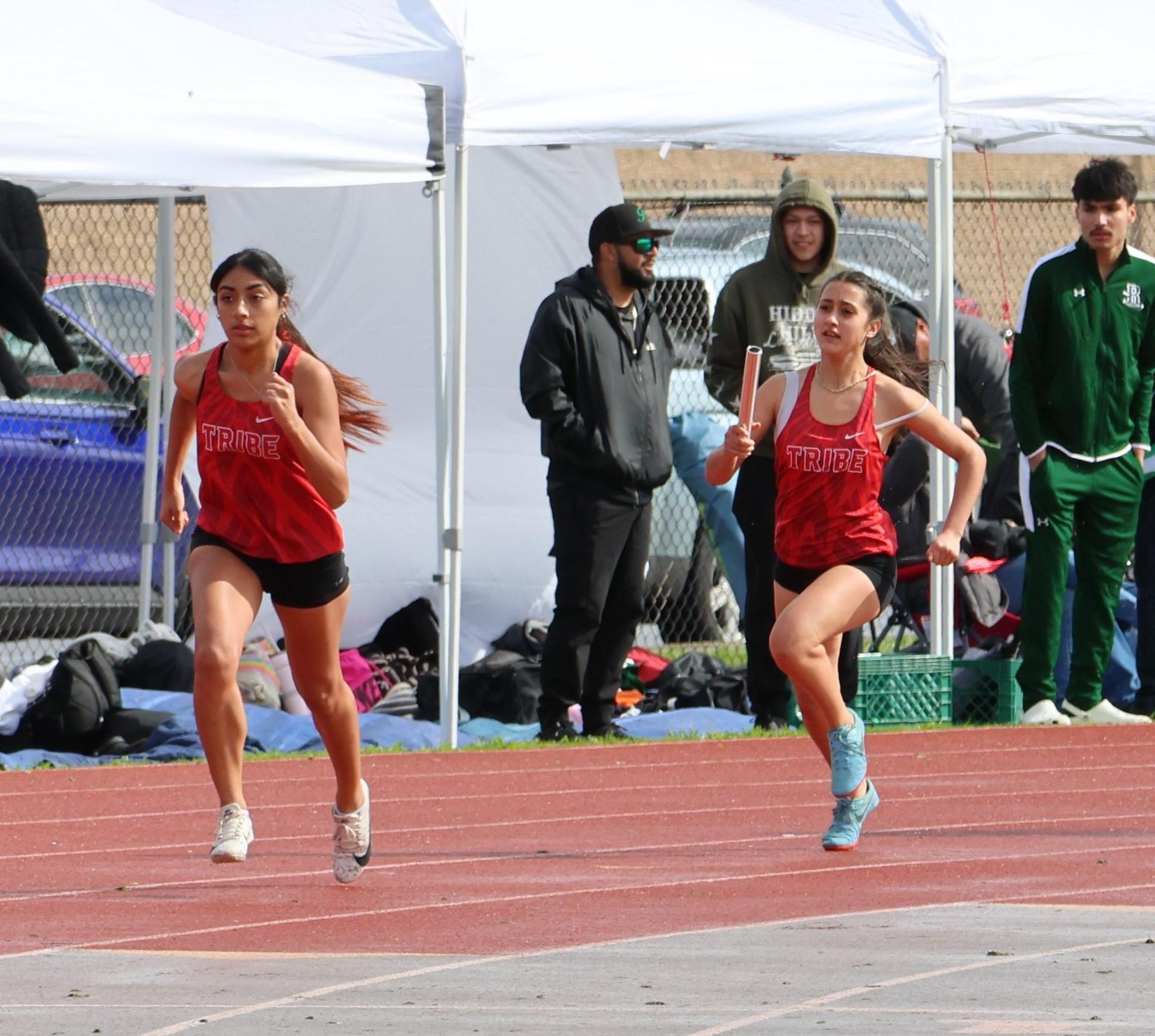 girls running the four by 100 meter relay
