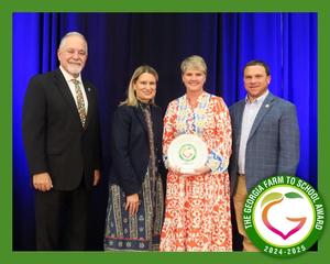 Four leaders—Richard Woods, Holly Thaw, Tyler Harper, and Nicole Blalock—pose together after Banks County Schools is recognized with the Georgia Farm to School Award.