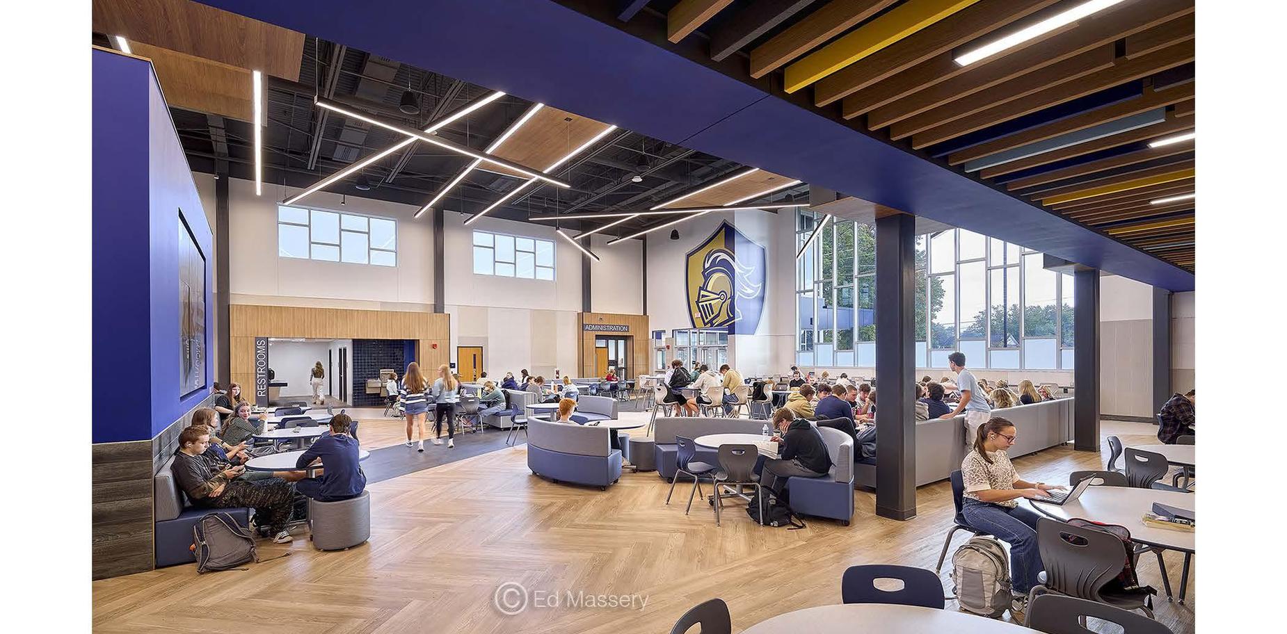 Spacious school hub with students studying, collaborating, and enjoying refreshments.