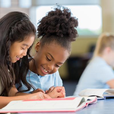 two students reading a book together