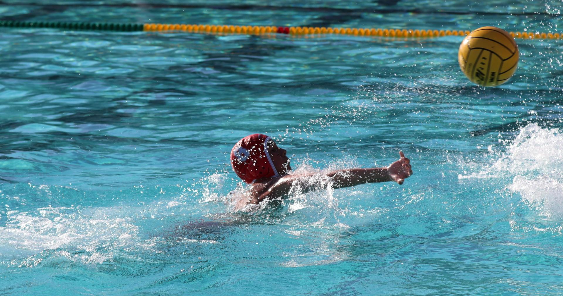 boys water polo players in action against hoover