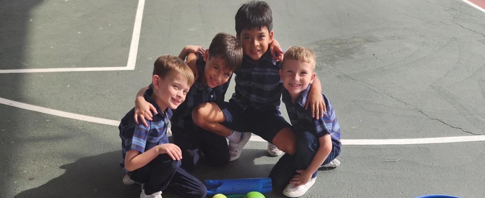 Two children with sports equipment arranged in a playful layout on the ground.
