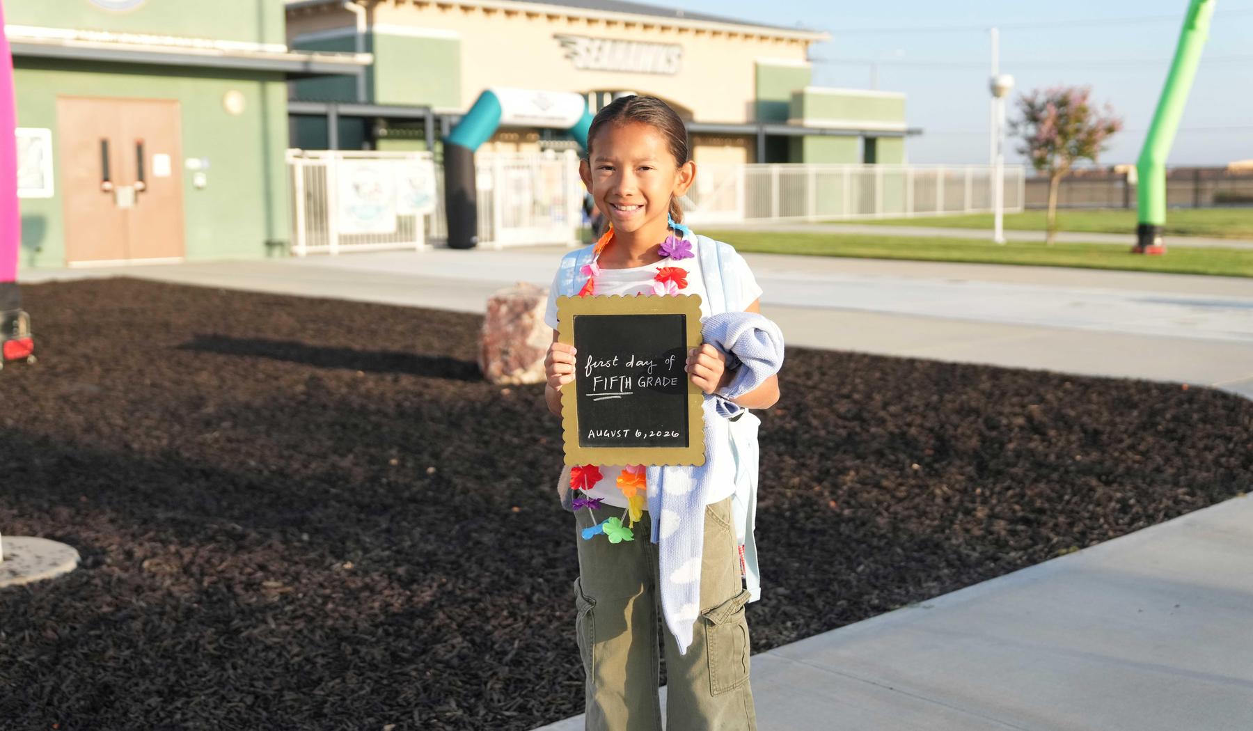 Girl holding 1st day of school sign