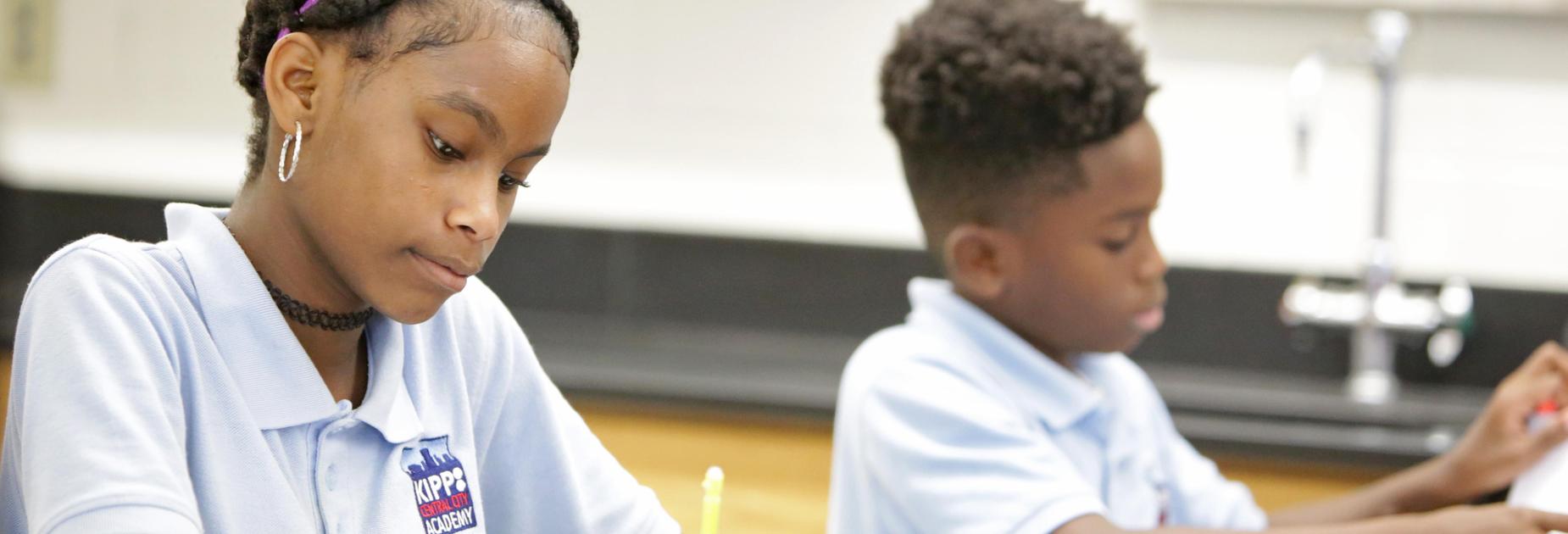 a female and male KCCA student working at a desk in a science lab