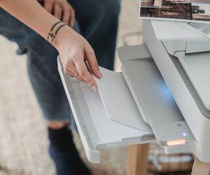 person loading paper into printer