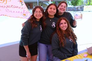 Four female students smile at the camera, taking part in the Mental Health Fair at La Serna High School.