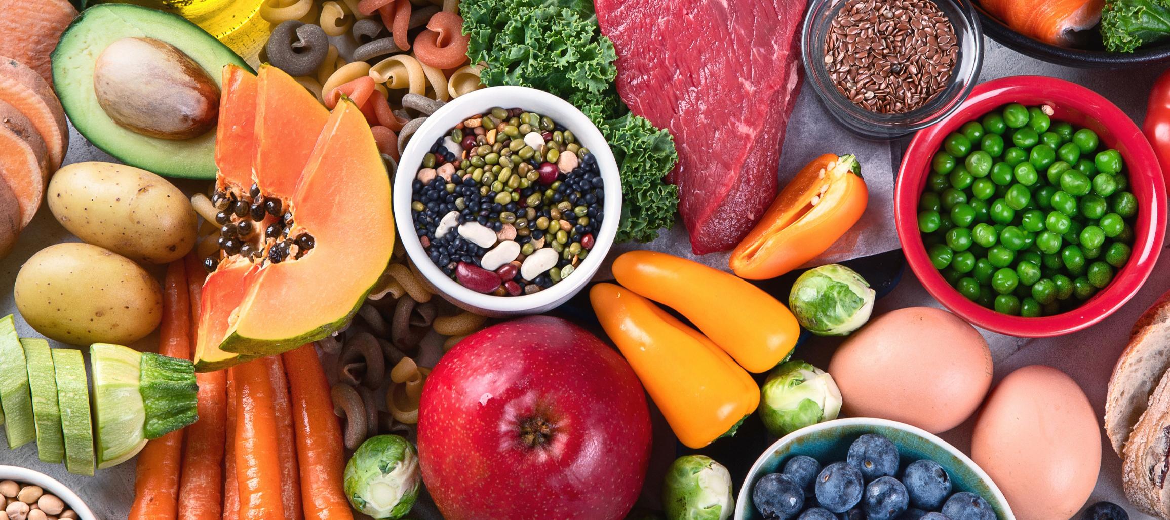 variety of healthy foods including meats, vegetables, eggs, fruit, legumes