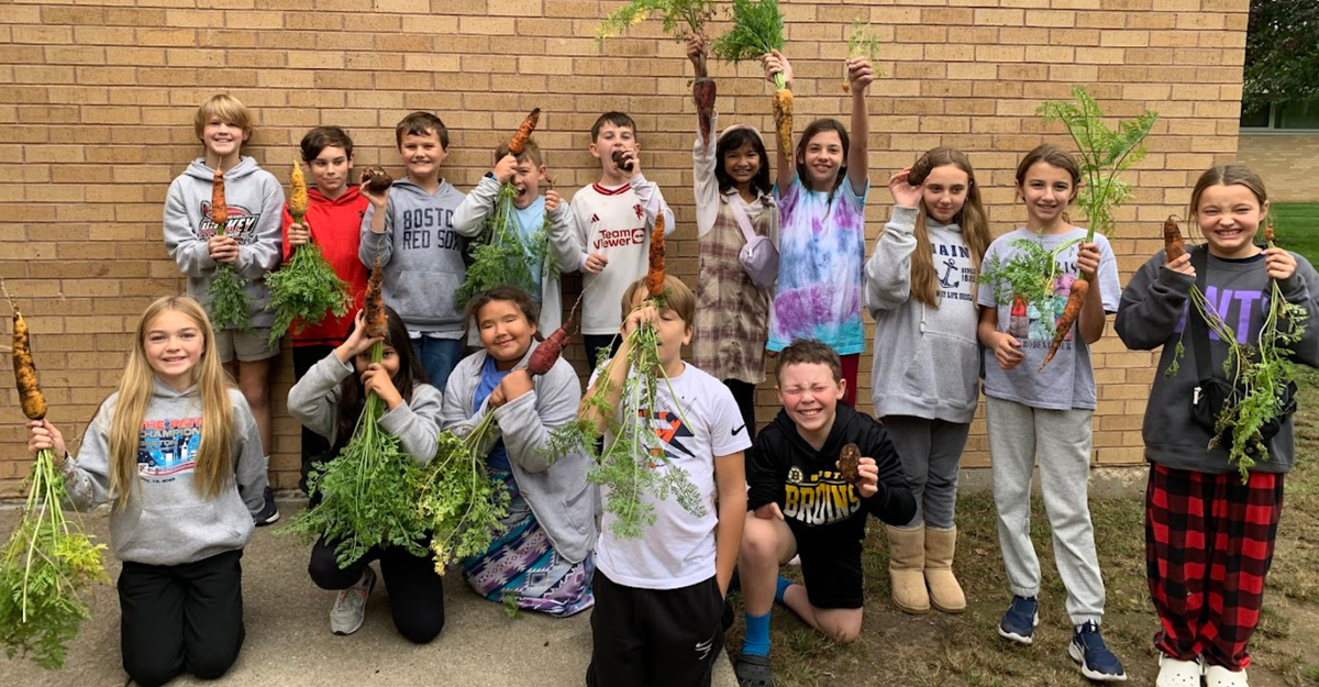 Students with carrots from the garden