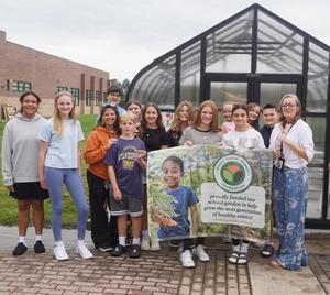 Students hold a sign thanking Whole Food Kids for their generous support.