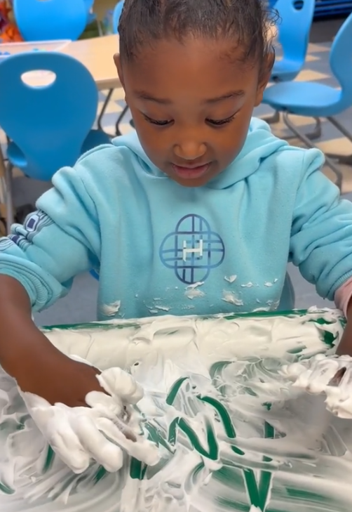 Using foam to write her first name.