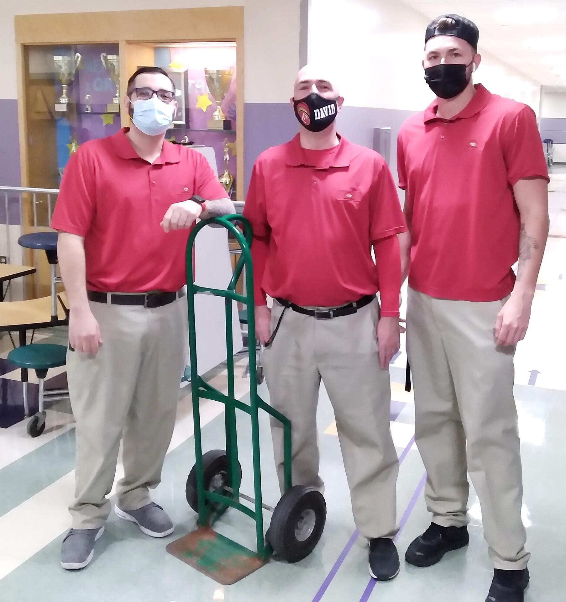 Three custodians, standing inside the Keverian lobby