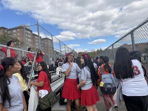 2 students by the bleachers with red ribbons