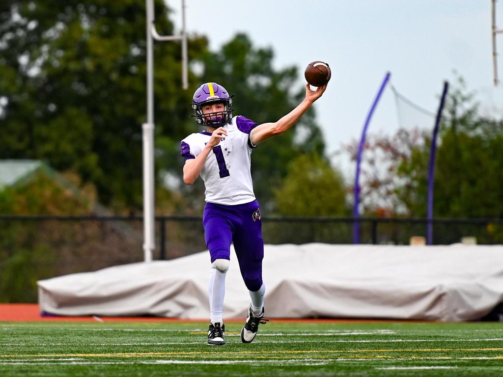 A football player in uniform throwing the football.