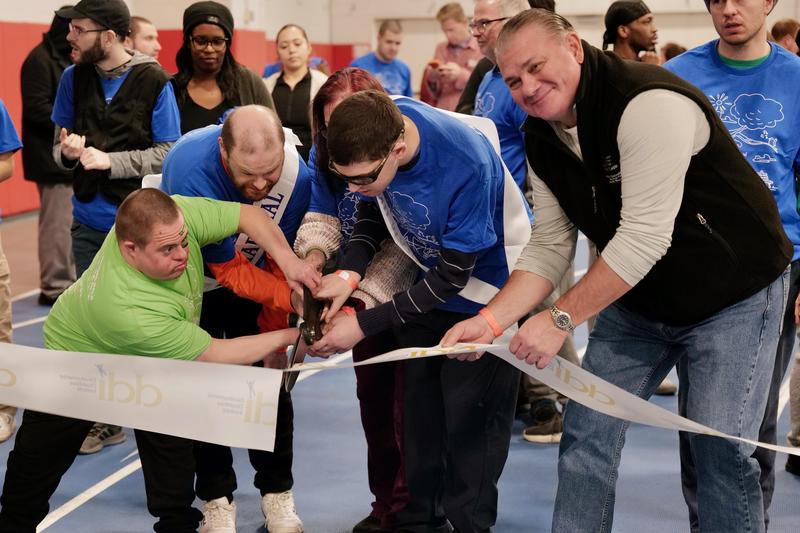 Three gentlemen cutting ribbon for Walk Fundraiser; people in the back getting ready to walk