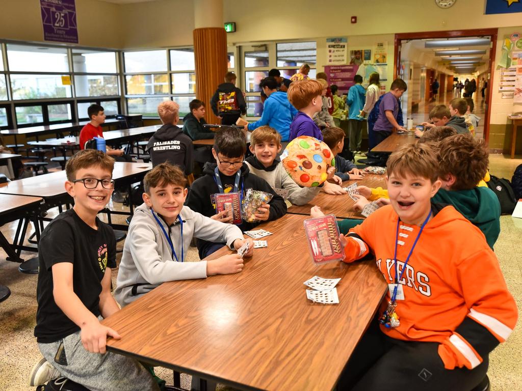 Students sitting at a table in the cafeteria for an after school club activity.
