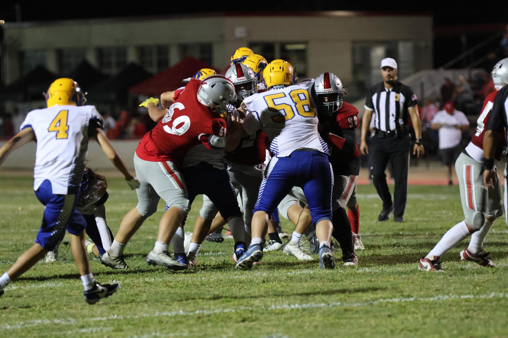 Varsity football players in action against Parlier 105