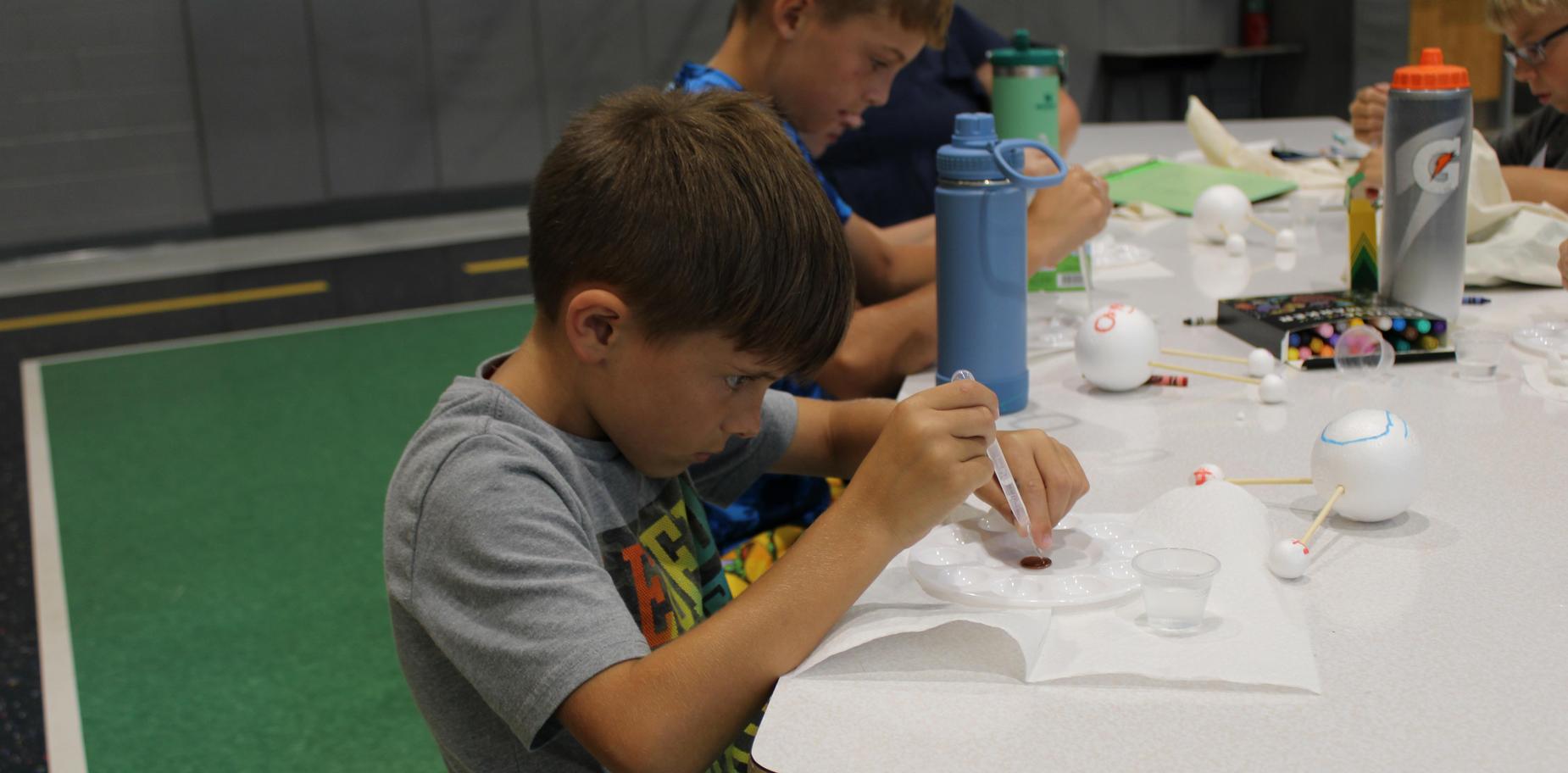 boy dripping water onto a penny