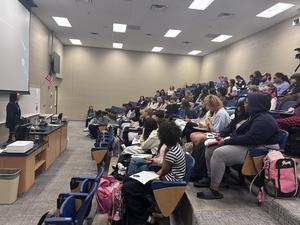 Man stands before students in crowded room