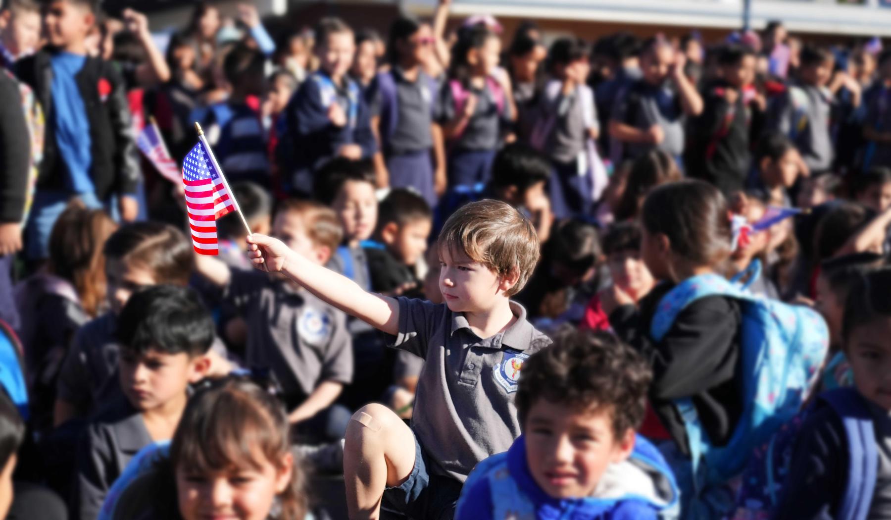 Student holding a flag in the middle of other students