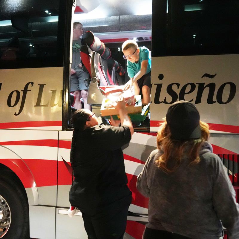 Toys are passed from the bus to a line of volunteers at the annual Unstuff the Bus event