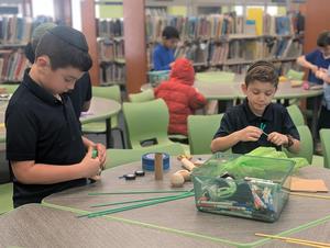 Two boys working together on an invention.
