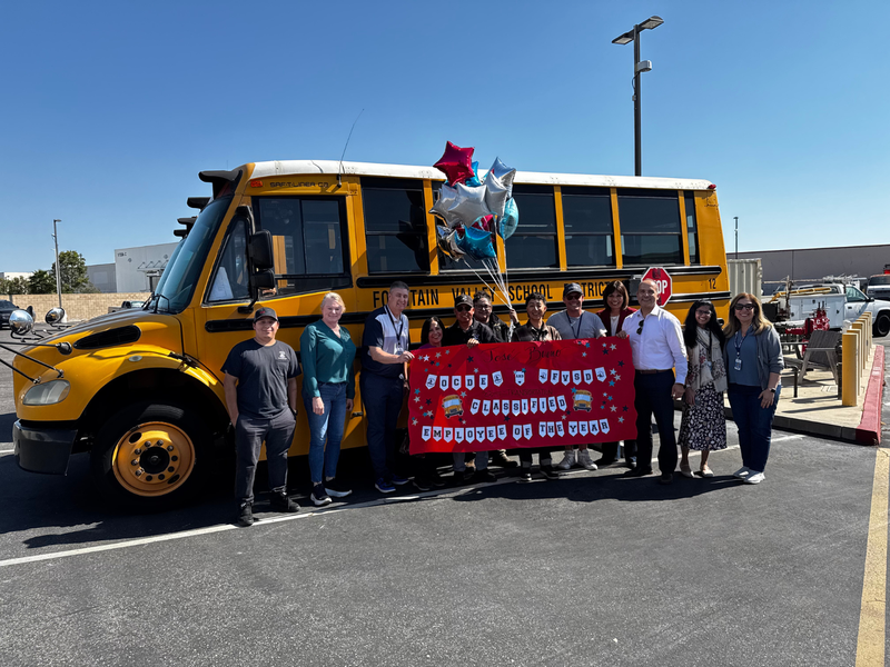 Bus with people, sign and balloons