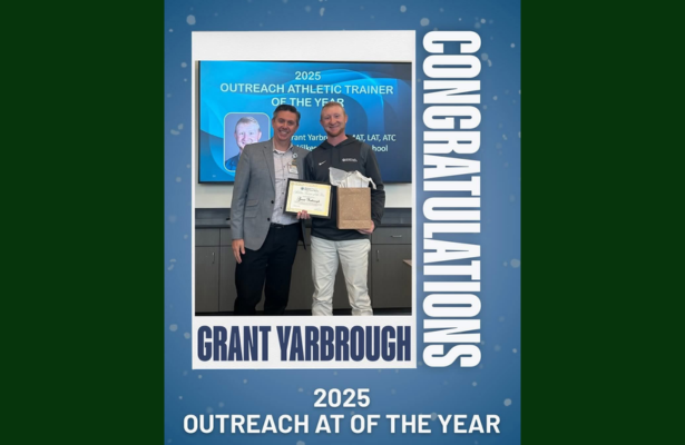 Two men celebrate with an award for 'Outreach Athletic Trainer of the Year' in 2025.