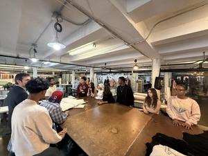 Group of people gathered around a large table in a creative workspace.