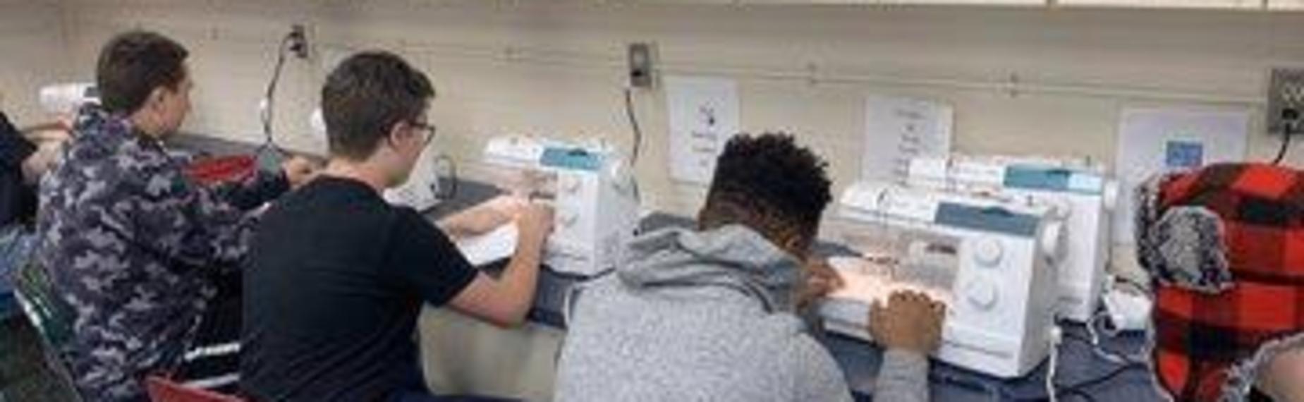 Students learning to use the sewing machine