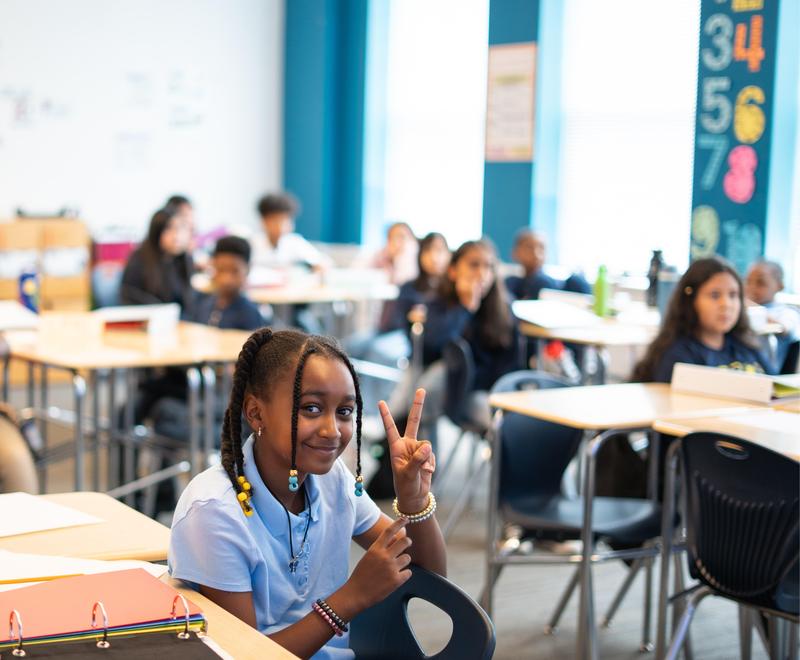 Students in class showing peace sign
