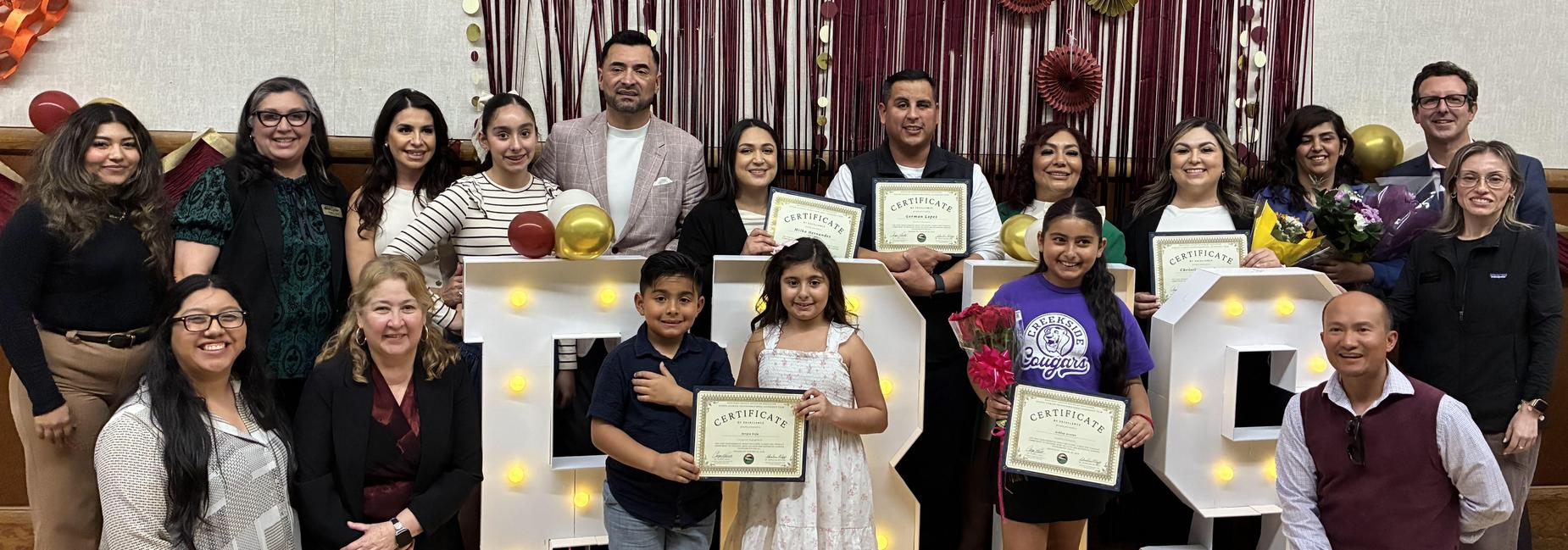 Alisal staff members, community members and their children standing in front of a PBIS sign
