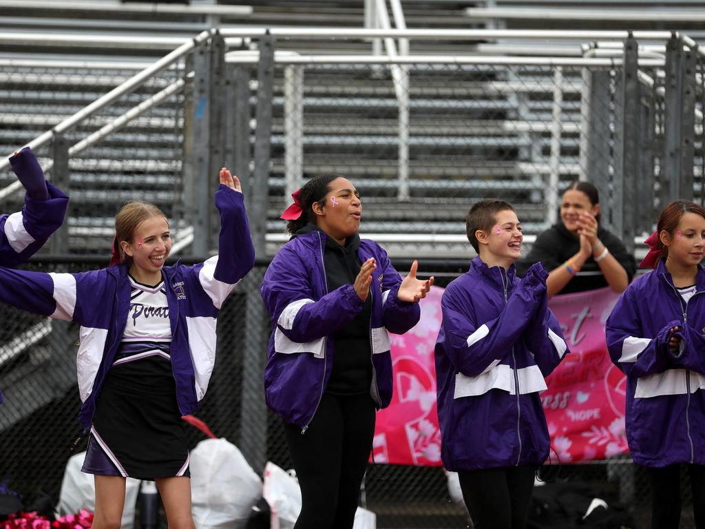 Four cheerleaders cheering on the sidelines.