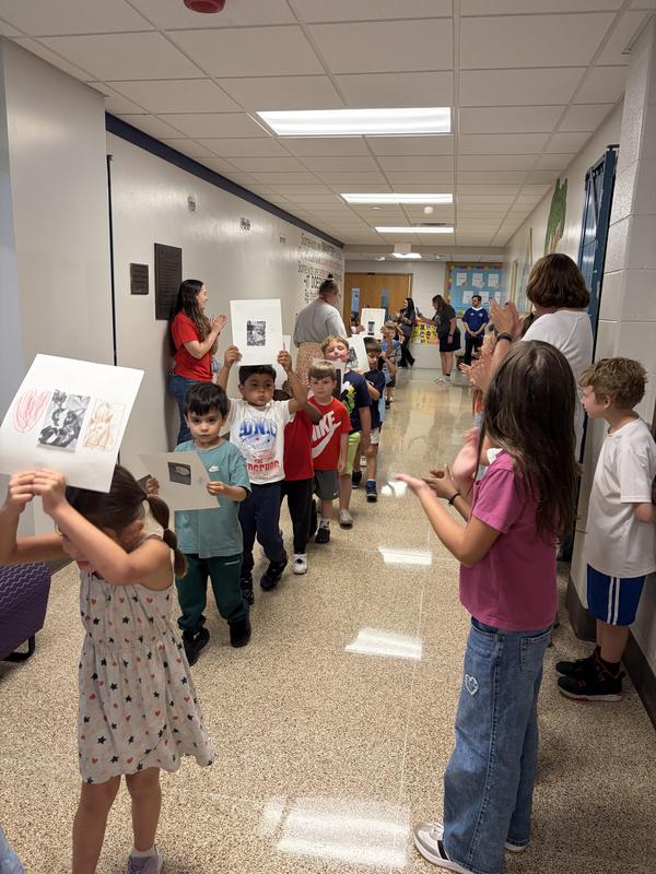 Students holding pictures of their pets